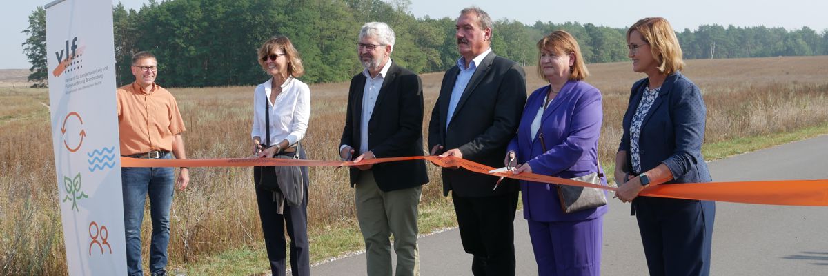 Minister Vogel und weitere Personen schneiden das Band zur Einweihung des Radweges durch.